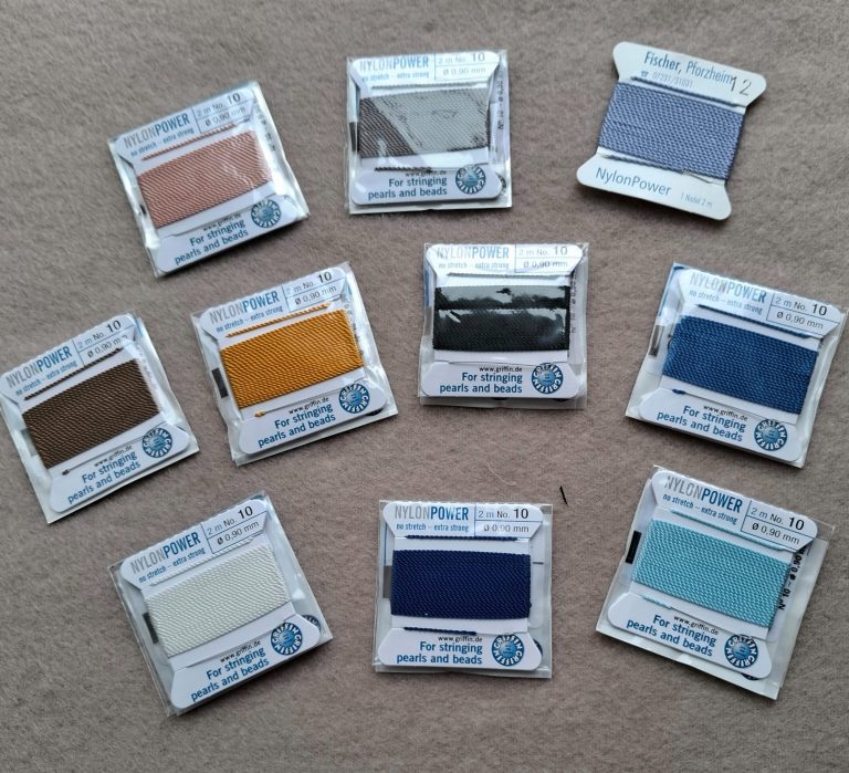Malaschnur in verschiedenen Farben Malaschnur in zehn Farbmuster in kleinen Verpackungen, verteilt auf einem hellen Untergrund.