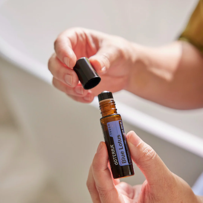 Hände halten eine braune Flasche mit ätherischem Öl und schwarzem Deckel.