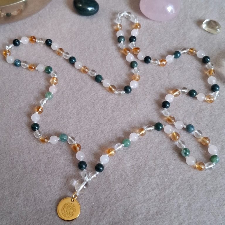Eine Halskette aus bunten Perlen mit einem silbernem Anhänger gelbvergoldet